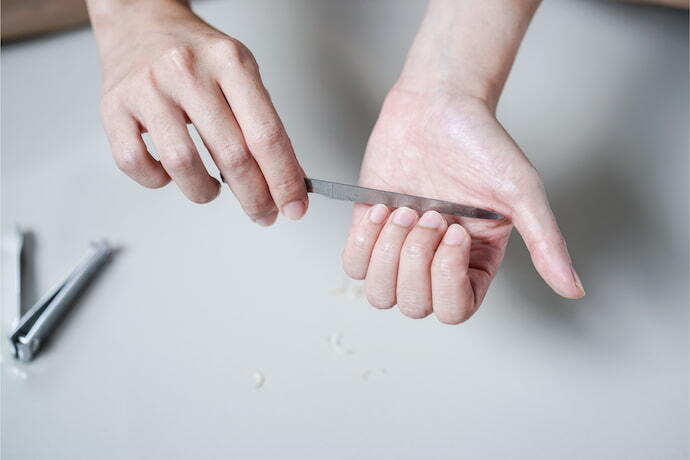 Mulher lixando as unhas