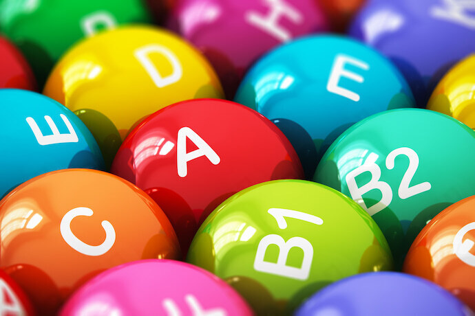 Alguns comprimidos coloridos com nomes de vitaminas estampados 