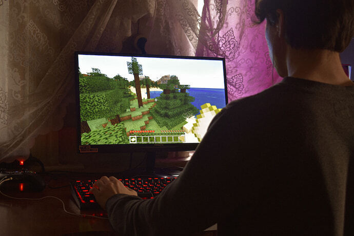 Pessoa jogando e utilizando monitor gamer